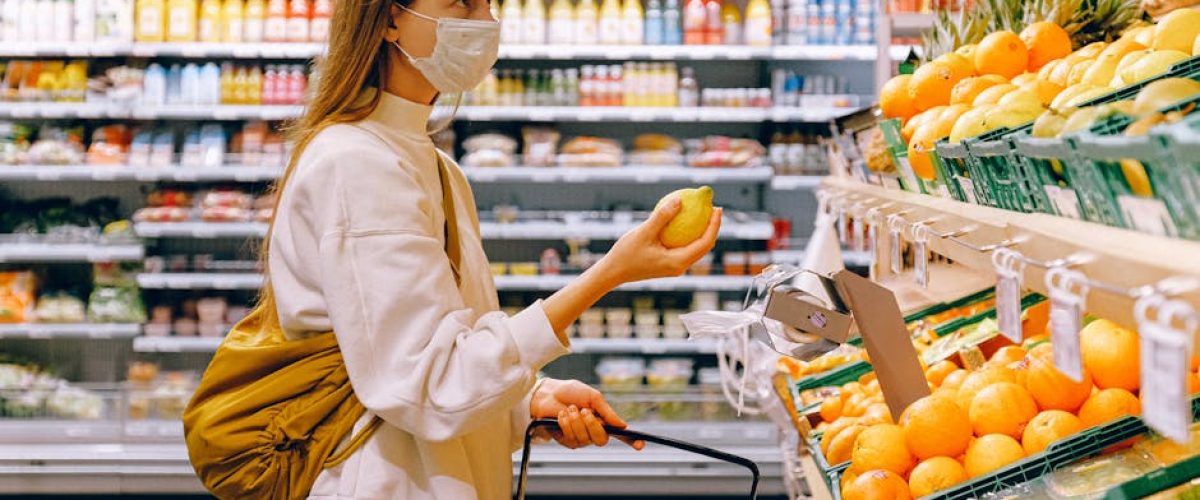 A woman wearing a face mask shops for fruits in a supermarket during a pandemic.